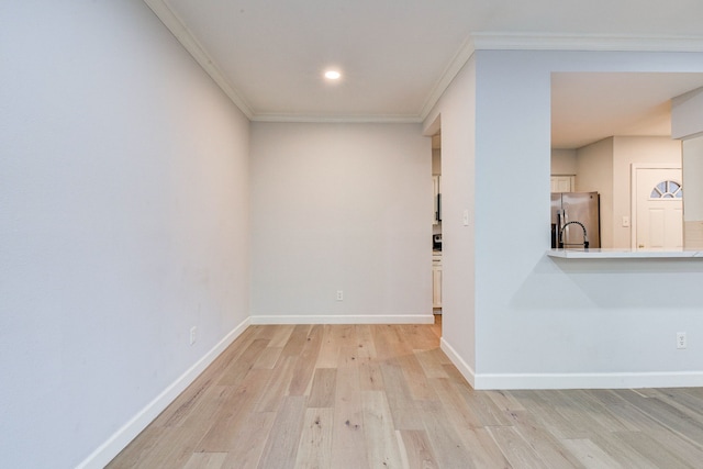 spare room with light hardwood / wood-style flooring and crown molding