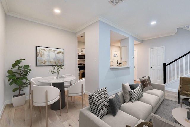 living room with light hardwood / wood-style floors and ornamental molding