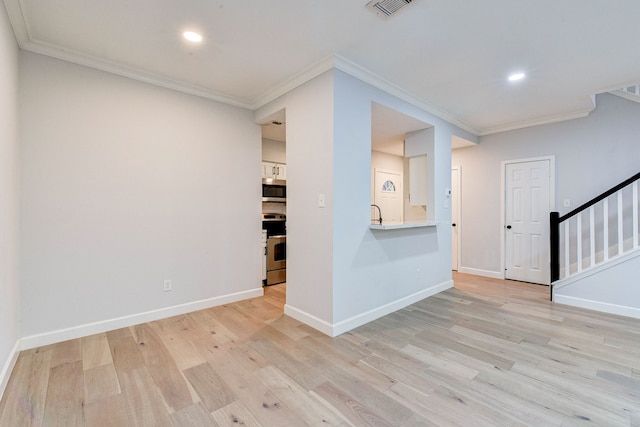 spare room featuring light wood-type flooring and ornamental molding