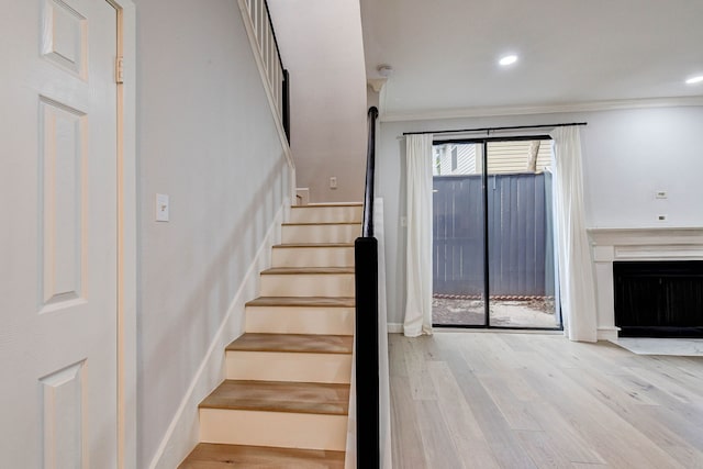 stairway featuring hardwood / wood-style flooring and crown molding