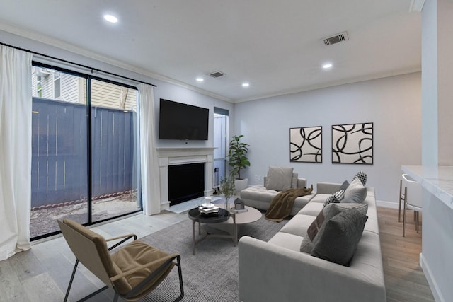 living room featuring ornamental molding and light wood-type flooring