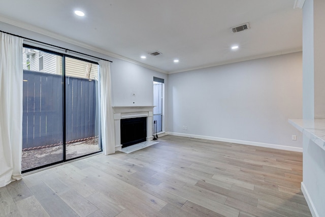 unfurnished living room featuring crown molding and light hardwood / wood-style flooring