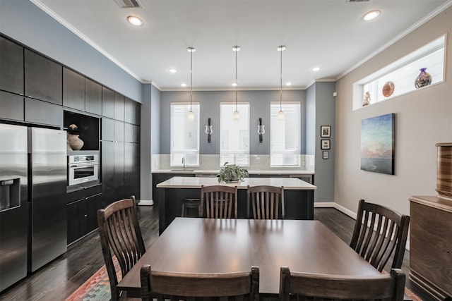 dining room with dark hardwood / wood-style flooring, ornamental molding, and sink