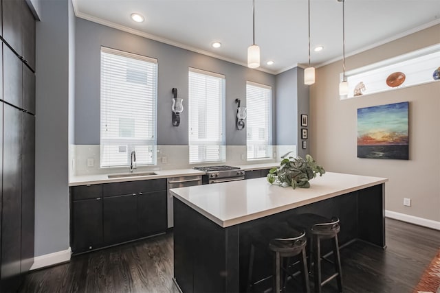 kitchen with sink, hanging light fixtures, a kitchen breakfast bar, dark hardwood / wood-style floors, and a kitchen island