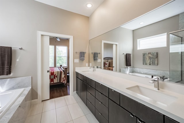 bathroom featuring tile patterned floors, tiled bath, and vanity