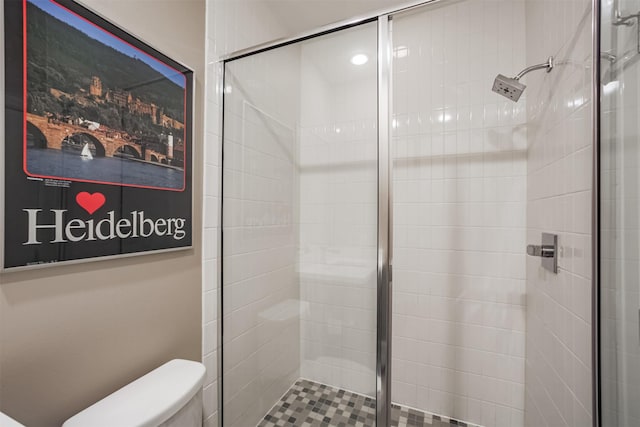 bathroom with a tile shower and toilet