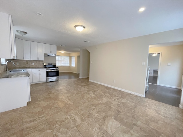 kitchen featuring backsplash, white cabinetry, stainless steel range with gas cooktop, and sink