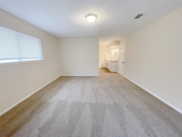 carpeted spare room with a textured ceiling