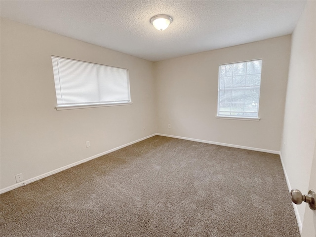 carpeted spare room with a textured ceiling