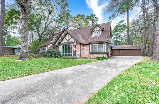 tudor home featuring a garage and a front yard