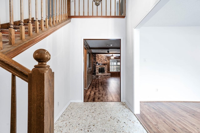 entryway featuring ceiling fan and a fireplace