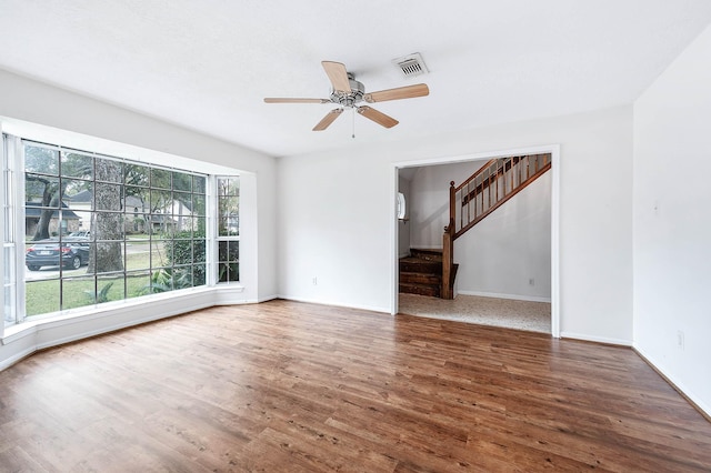 unfurnished living room with ceiling fan and dark wood-type flooring