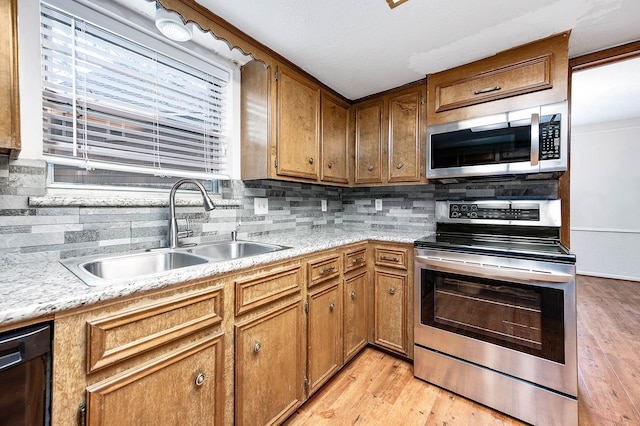 kitchen with stainless steel appliances, light hardwood / wood-style flooring, backsplash, and sink