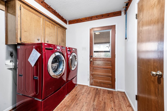 laundry area with light hardwood / wood-style floors, crown molding, washer and clothes dryer, a textured ceiling, and cabinets