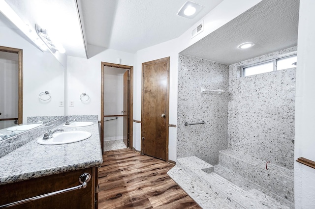 bathroom with a textured ceiling, hardwood / wood-style flooring, and vanity