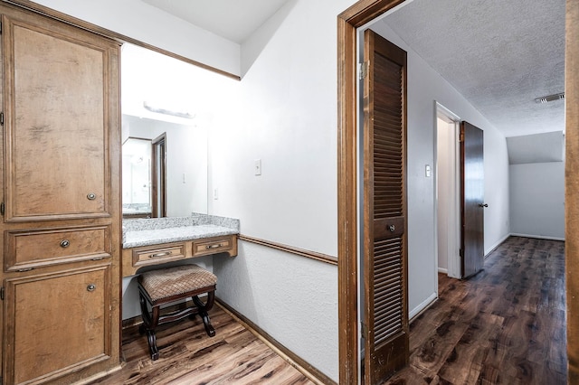 interior space with lofted ceiling, a textured ceiling, and hardwood / wood-style flooring