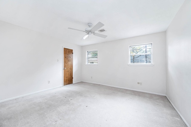 carpeted empty room featuring ceiling fan and a wealth of natural light