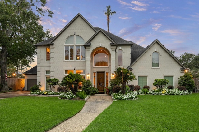 view of front of home with a garage and a lawn