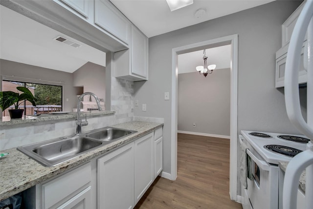 kitchen featuring tasteful backsplash, sink, a chandelier, light hardwood / wood-style floors, and white cabinetry