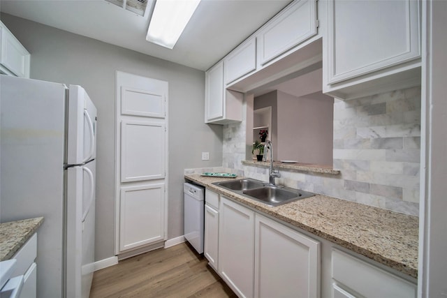 kitchen with tasteful backsplash, white appliances, sink, light hardwood / wood-style flooring, and white cabinets