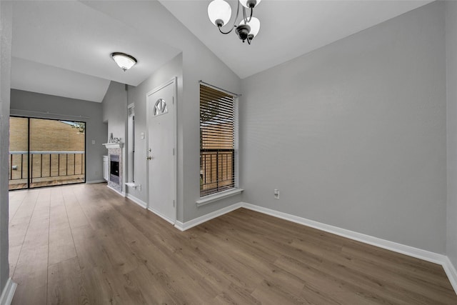 interior space featuring hardwood / wood-style floors, lofted ceiling, and a notable chandelier