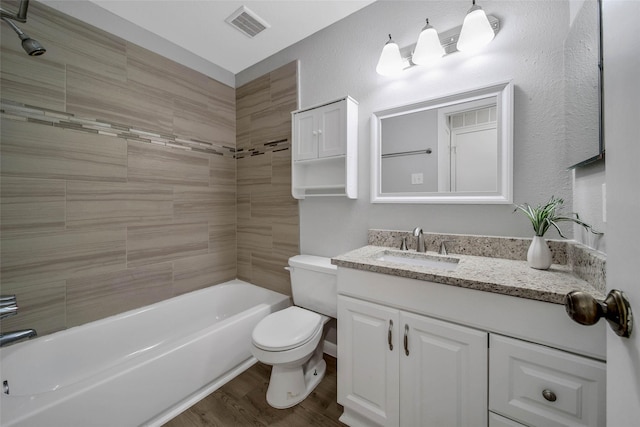 full bathroom featuring vanity, hardwood / wood-style flooring, toilet, and tiled shower / bath