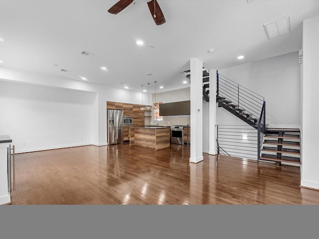 living room featuring dark hardwood / wood-style flooring, ceiling fan, and sink