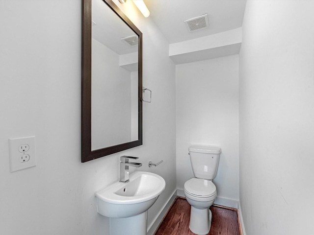 bathroom featuring hardwood / wood-style flooring, toilet, and sink