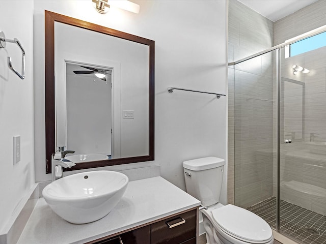 bathroom featuring walk in shower, ceiling fan, vanity, and toilet