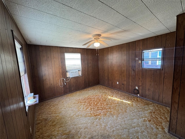 spare room featuring ceiling fan, wooden walls, and cooling unit