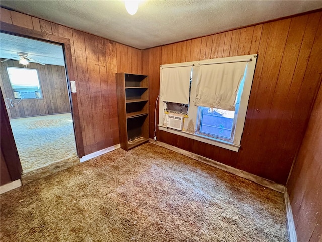 unfurnished bedroom with carpet, a textured ceiling, and wooden walls