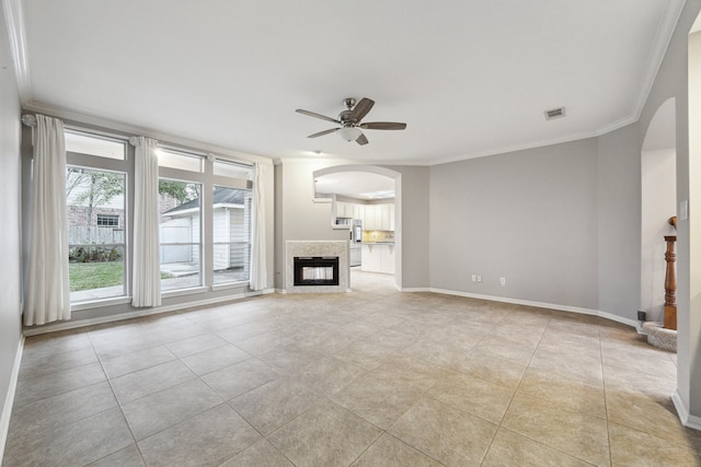 2109 Enchanted Lake Dr, League City, TX 77573 - unfurnished living room with arched walkways, crown molding, a ceiling fan, light tile patterned floors, and a multi sided fireplace
