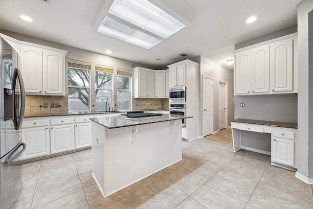 2109 Enchanted Lake Dr, League City, TX 77573 - kitchen with stainless steel appliances, backsplash, white cabinetry, and recessed lighting
