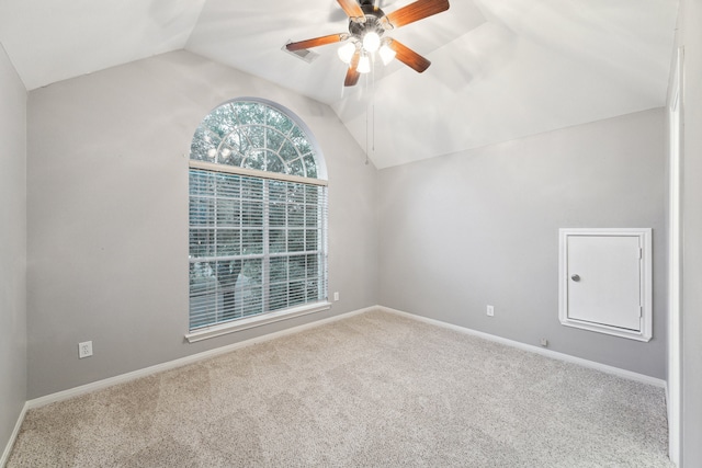 empty room with ceiling fan, carpet flooring, and vaulted ceiling