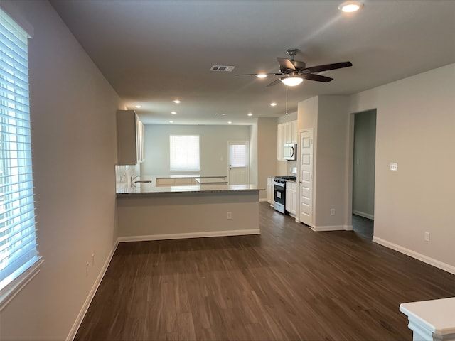 kitchen featuring kitchen peninsula, appliances with stainless steel finishes, ceiling fan, dark wood-type flooring, and white cabinets