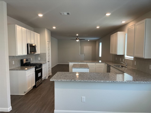 kitchen with kitchen peninsula, white cabinetry, and appliances with stainless steel finishes