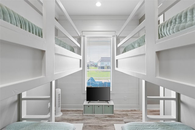 bedroom with wooden walls and light wood-type flooring