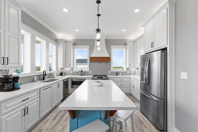 kitchen featuring white cabinets, custom exhaust hood, a center island, and appliances with stainless steel finishes