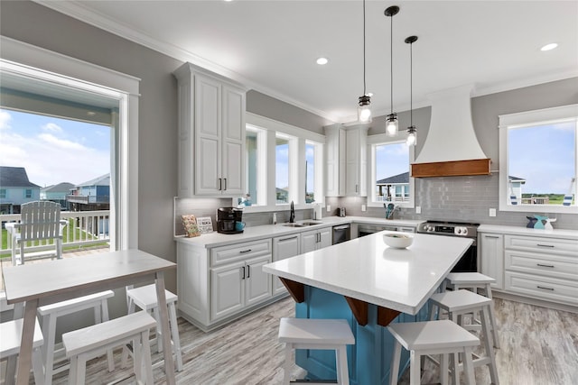 kitchen featuring tasteful backsplash, stainless steel electric range, a kitchen bar, a kitchen island, and custom exhaust hood