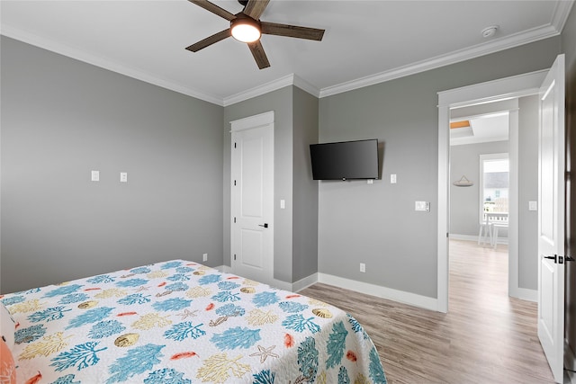 bedroom featuring light hardwood / wood-style flooring, ceiling fan, and ornamental molding