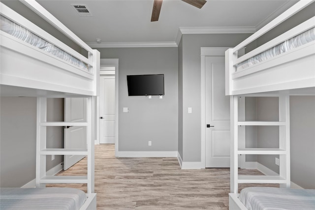 unfurnished bedroom with ceiling fan, light wood-type flooring, and crown molding