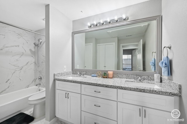 full bathroom featuring tiled shower / bath, vanity, and toilet