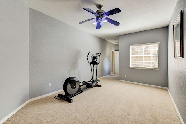 exercise room with ceiling fan and light colored carpet