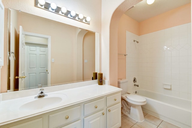 full bathroom featuring toilet, vanity, tiled shower / bath combo, and tile patterned floors