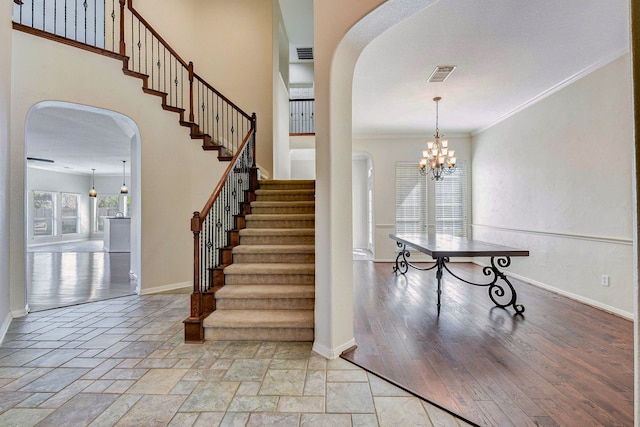 stairs featuring crown molding and a notable chandelier