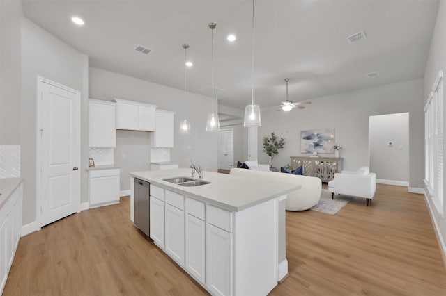 kitchen with sink, dishwasher, a kitchen island with sink, white cabinetry, and decorative light fixtures