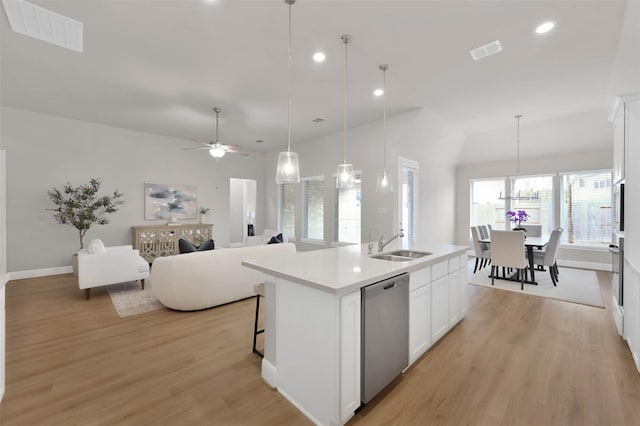 kitchen featuring sink, white cabinetry, a center island with sink, pendant lighting, and stainless steel appliances