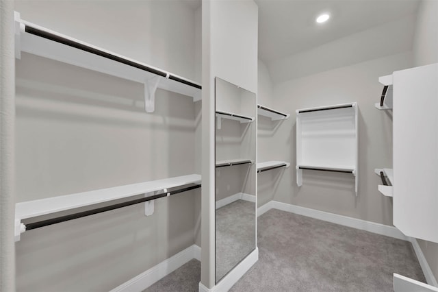 walk in closet featuring light carpet