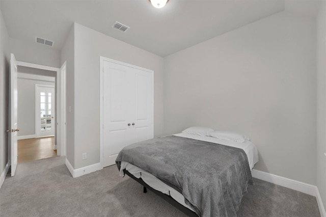 bedroom featuring light carpet and a closet