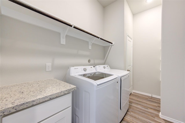 clothes washing area with separate washer and dryer and light hardwood / wood-style flooring